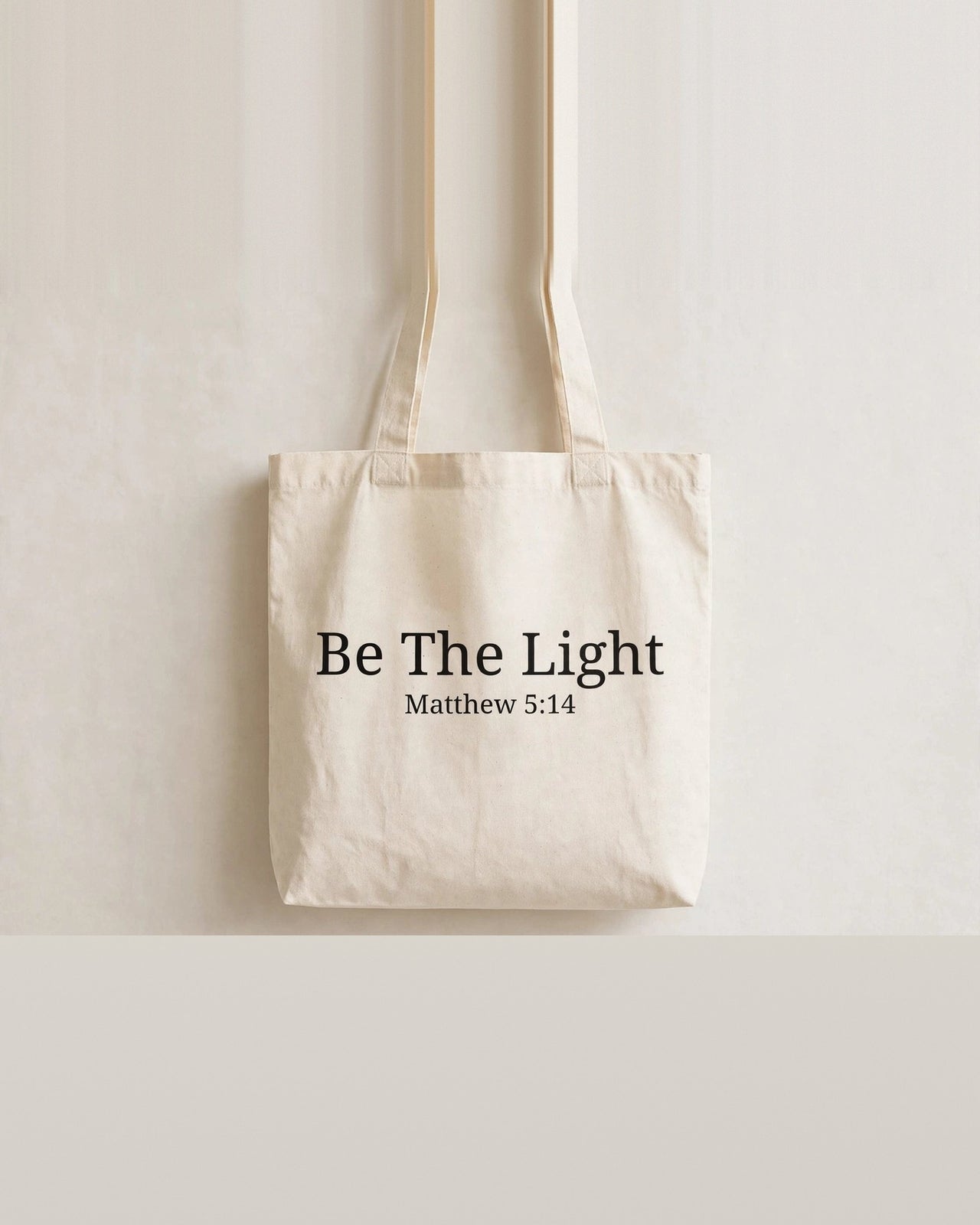 Natural cotton tote bag front with black Be The Light Matthew 5:14 print - Christian tote bag