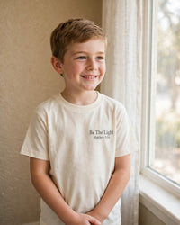 Thumbnail for Kids Be The Light Tee - worn front by the window, Cream