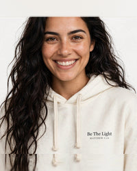 Thumbnail for Woman wearing the Be The Light hoodie in cream