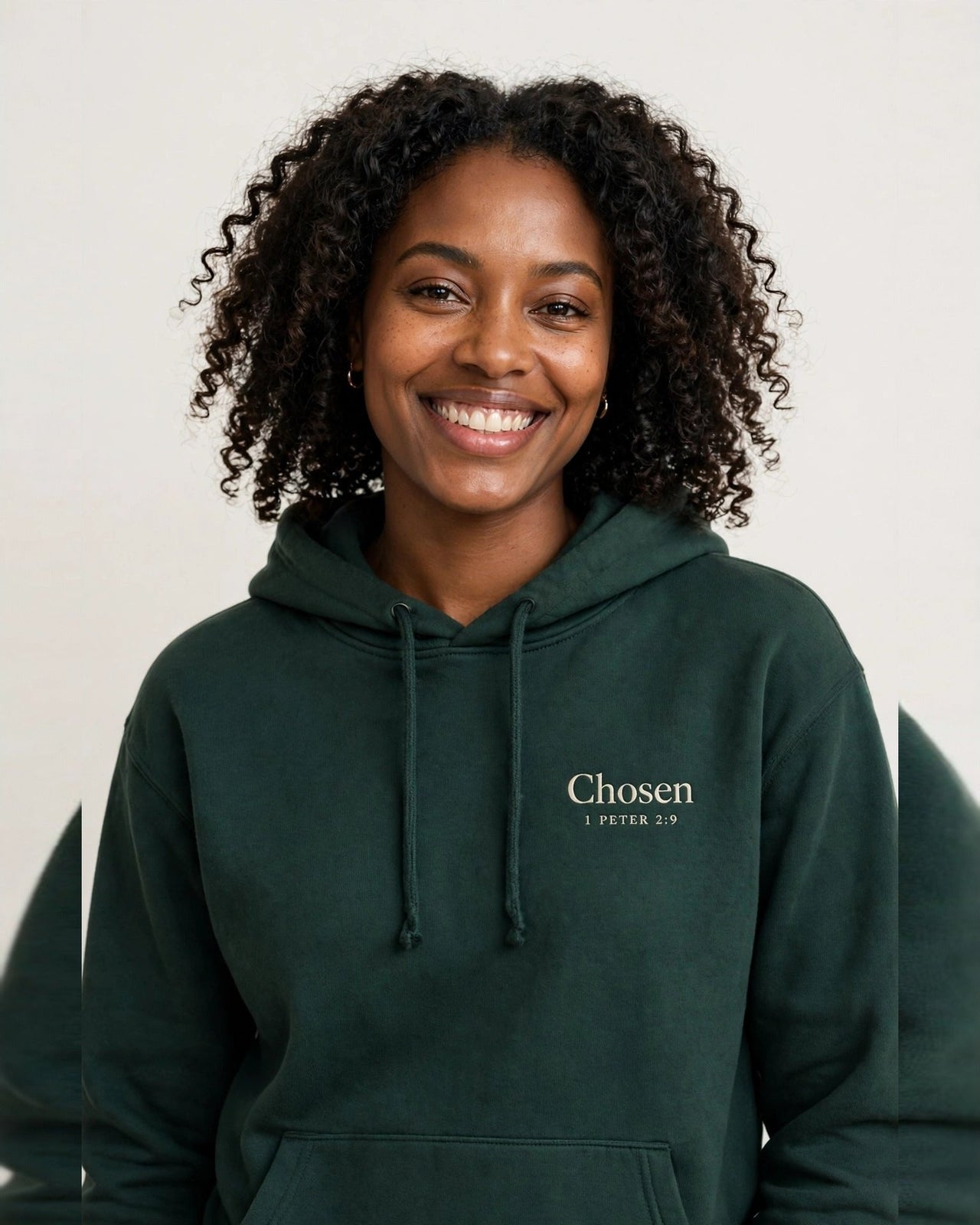 Woman wearing the Chosen hoodie in dark green