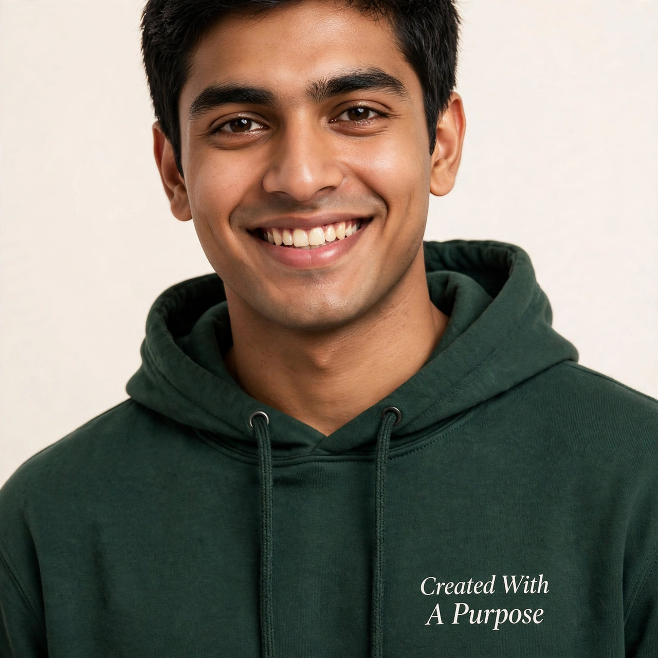 Man wearing the Created With A Purpose hoodie in dark green