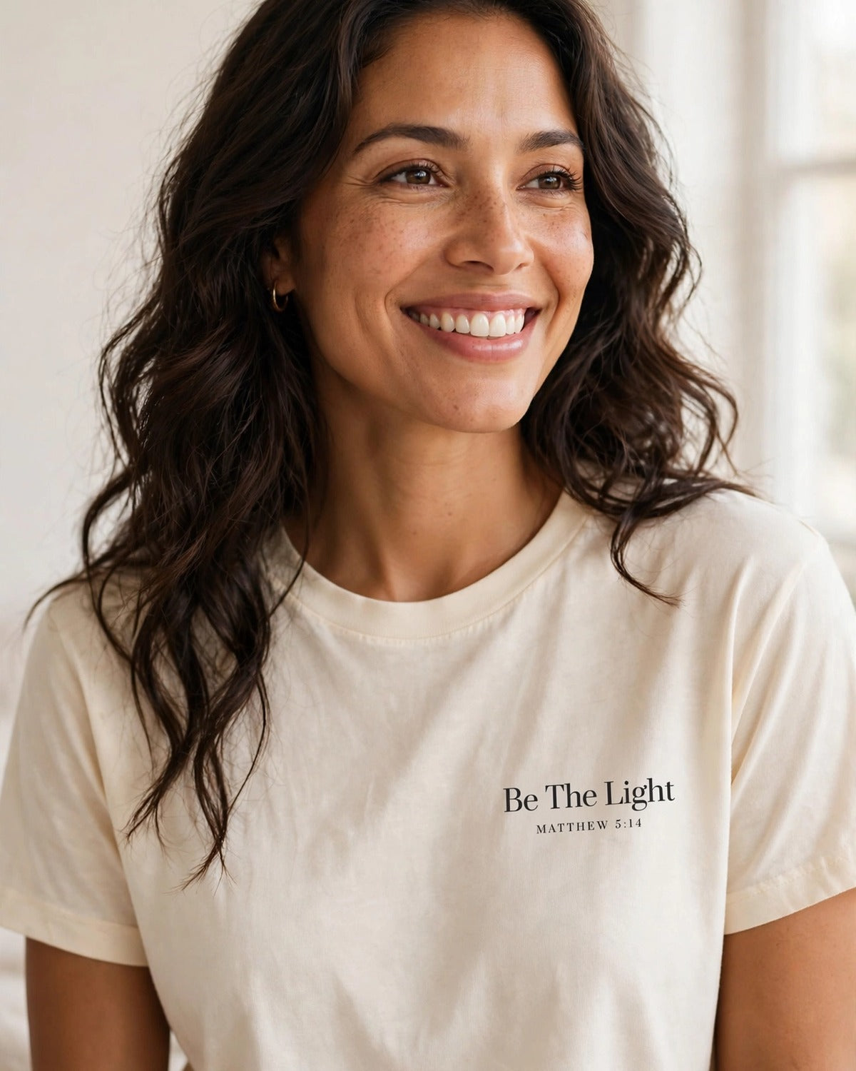 Woman wearing the Be The Light tee in cream