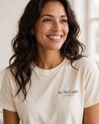 Thumbnail for Woman wearing the Be The Light tee in cream